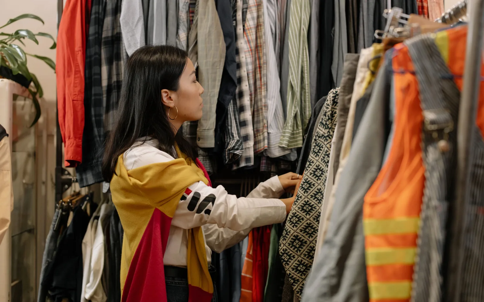 Une cliente passe en revue un portant de vêtements de seconde main